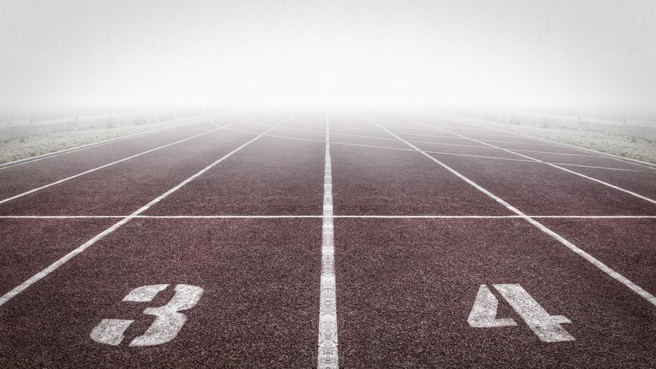 A foggy track field with visible lane numbers and white lines.