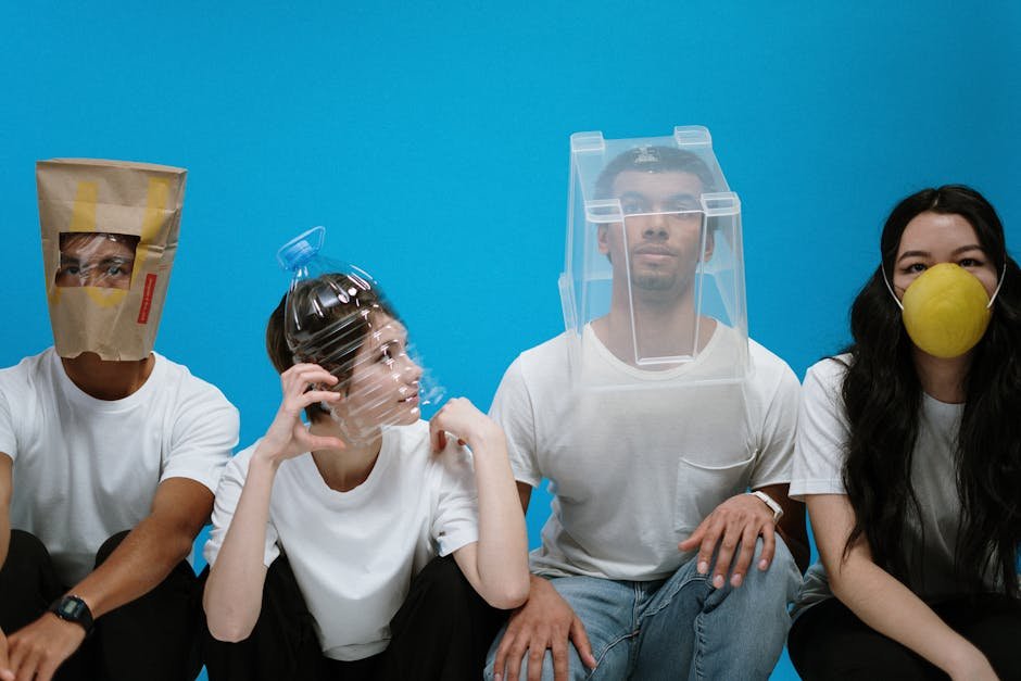 Four people wearing humorous DIY face masks against a blue background, showcasing creativity and humor.