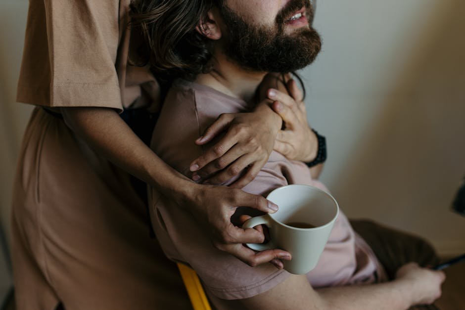 A couple in a warm embrace enjoying coffee, embodying a relaxed and loving atmosphere.